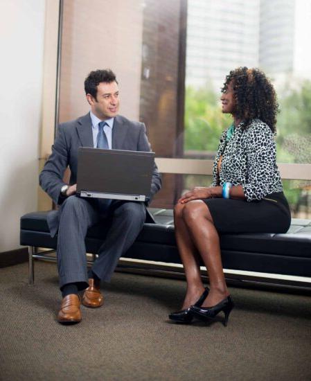 Two business people talking in a waiting room.